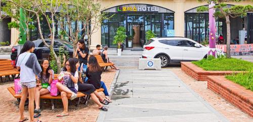 a group of people sitting on a park bench at Hotel Lohas in Boryeong
