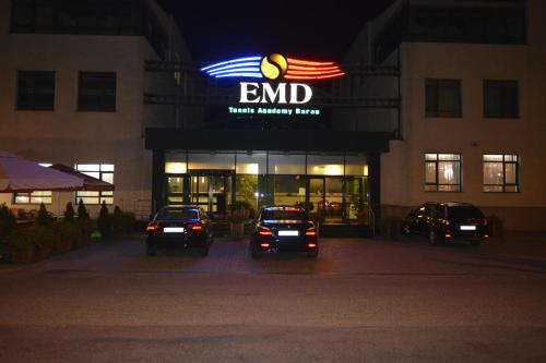 a store with cars parked in front of it at night at Hotel EMD in Bacău