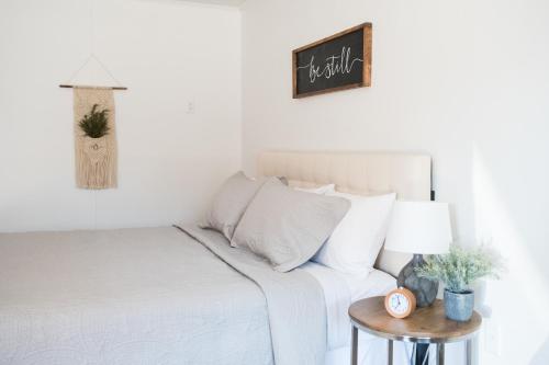 a white bedroom with a bed and a table at The Carriage House at Strasburg in Strasburg