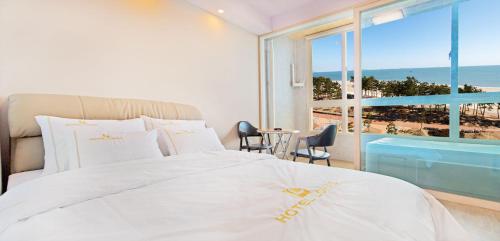 a bedroom with a bed and a view of the beach at Hotel Lohas in Boryeong