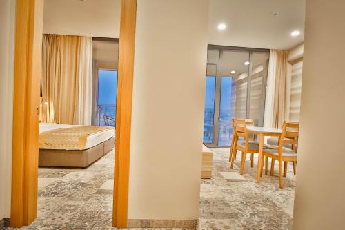 a bedroom with a bed and a dining room with a table at Ameri Plaza Tbilisi in Tbilisi City