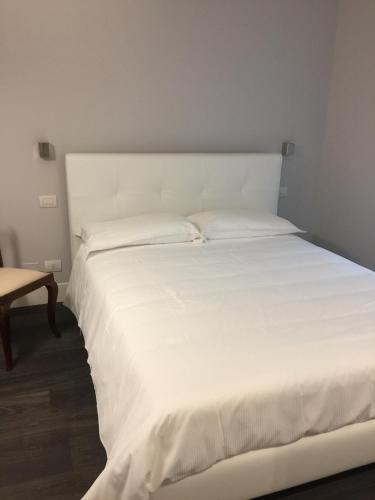 a white bed in a room with a table at La Casa di Paola in Lovere