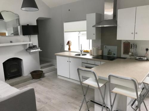 a kitchen with a fireplace and a table and chairs at Hobbit Hollow in Ballymore Eustace