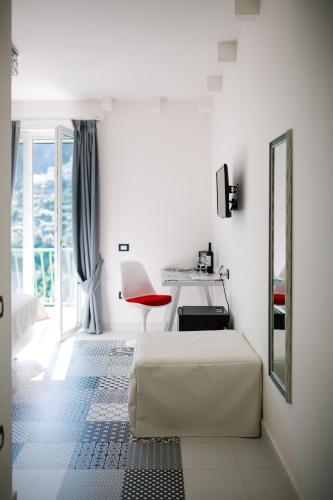 a white bedroom with a bed and a desk at Rosa e Valentino in Ravello