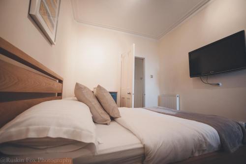 a bedroom with a bed with a flat screen tv on the wall at Prime 2 Bedroom City Centre Apt in Aberdeen