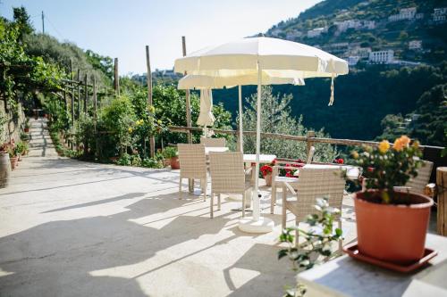 a patio with a table and chairs and an umbrella at Rosa e Valentino in Ravello