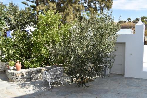 a white bench sitting in front of a garage at Andriani's Guest House in Mýkonos City