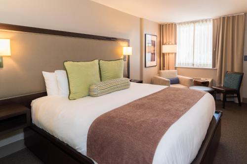 Cette chambre comprend un grand lit avec des oreillers verts. dans l'établissement City Loft Hotel, à Beaufort