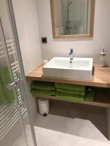a bathroom with a white sink and green towels at Le Nautile in Hyères