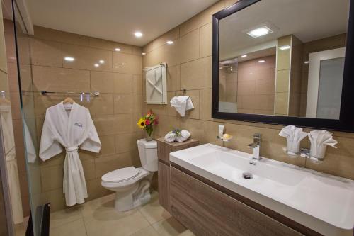 a bathroom with a sink and a toilet and a mirror at Divi Dutch Village Beach Resort in Palm-Eagle Beach