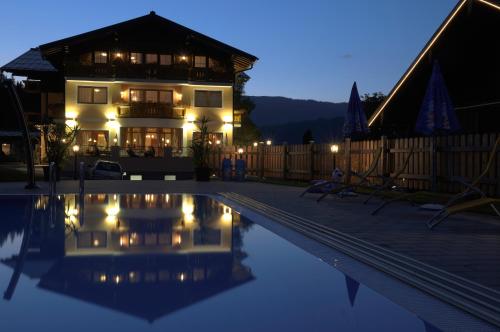 a house with a swimming pool at night at Natur & Familienhotel Der Stieglerhof in Radstadt