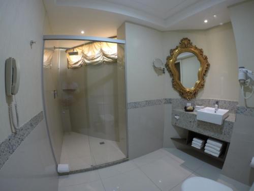 a bathroom with a shower and a sink and a mirror at Best Western Premier Majestic Ponta Negra Beach in Natal