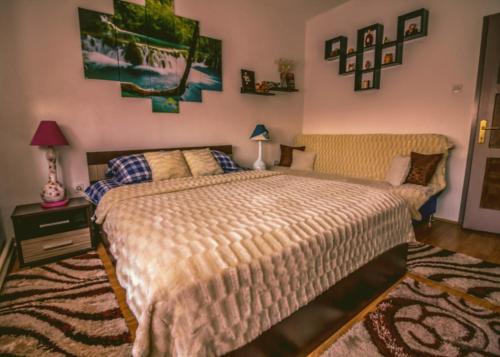 a bedroom with a large bed and a rug at Apartman Dimač in Topusko