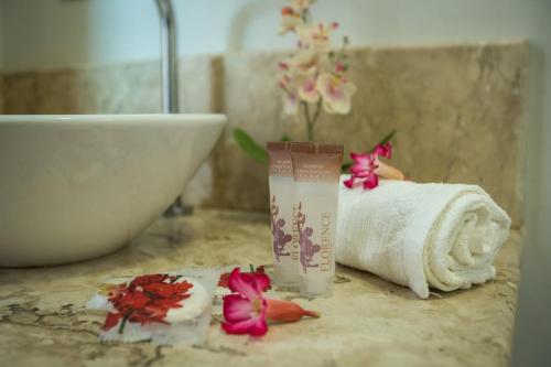 a bathroom with a towel and a sink and flowers at Pousada Vento Sul in Chapada dos Guimarães