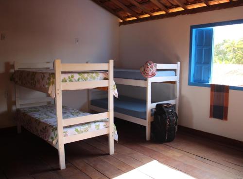 two bunk beds in a room with a window at Arte Vida Hostel Feminino in Itaúnas