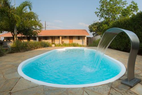 a pool with a water fountain in a yard at Pousada Vento Sul in Chapada dos Guimarães