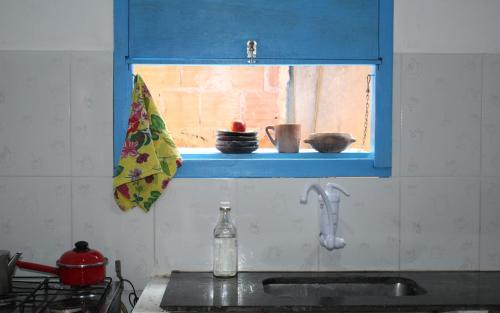 a kitchen with a sink and a window with bowls on it at Arte Vida Hostel in Itaúnas