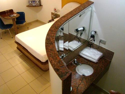 baño con lavabo y cama en Status Motel PE15 (Adults Only), en Olinda