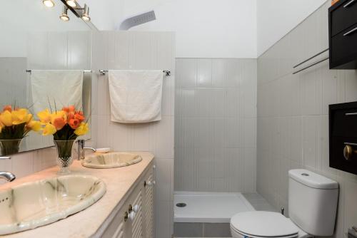 a white bathroom with a sink and a toilet at Verdizela Pool & Garden in Charneca