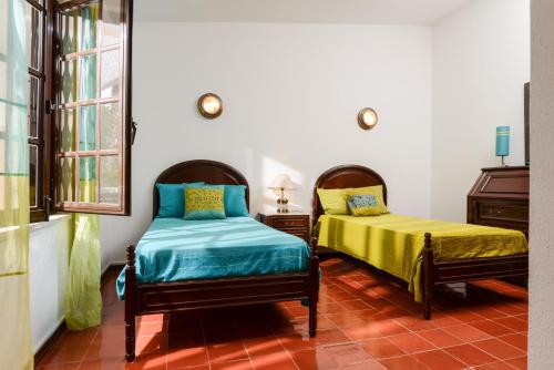 a bedroom with two beds and a window at Verdizela Pool & Garden in Charneca
