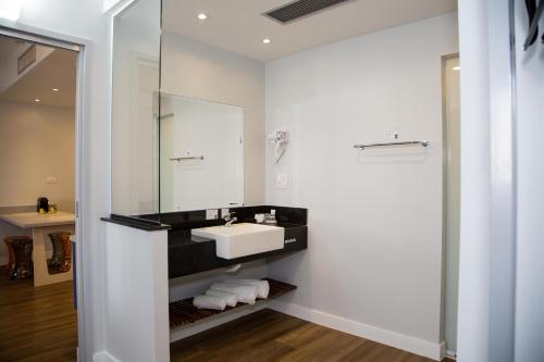 ein Bad mit einem Waschbecken und einem Spiegel in der Unterkunft All Inn Sorocaba in Sorocaba