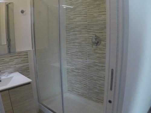 una ducha con puerta de cristal en un baño en I Vicini della Cattedrale, en Palermo