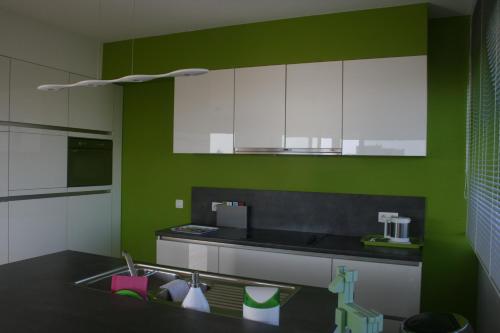 a kitchen with green and white cabinets and a sink at Scheldepunt in Ghent
