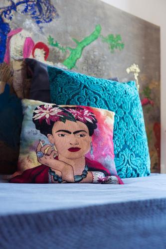 a pillow with a painting of a woman on a bed at La vie de chateau in Grignan