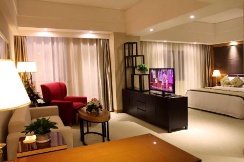 a living room with a television and a bed at Aurum International Hotel Xi'an in Xi'an
