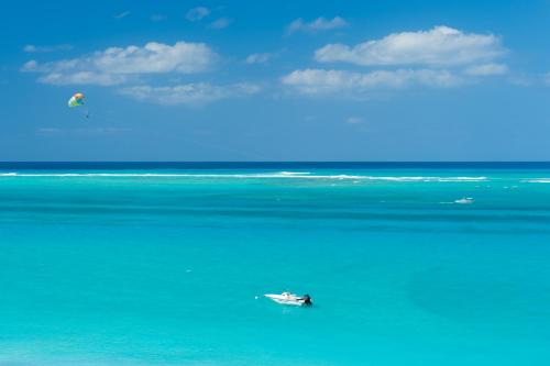 a boat in the ocean with a kite in the sky at The Regent Grand in Grace Bay