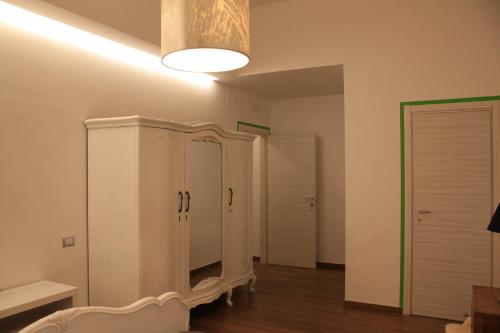 ein Wohnzimmer mit weißen Schränken und einer Leuchte in der Unterkunft Marchesa Lulu in Salerno
