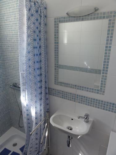 y baño con lavabo, espejo y ducha. en Casa Pelourinho, en Silves