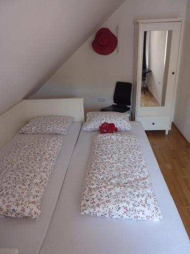 a bedroom with three beds with a red hat on top at Apartments Tabor43 in Cerknica