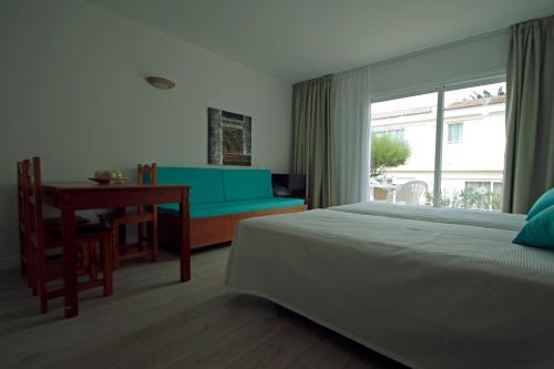 a bedroom with a bed and a desk and a window at Paradero II in Playa de las Americas