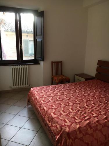 a bedroom with a red bed and a window at Res. CENTRO STORICO in Fano