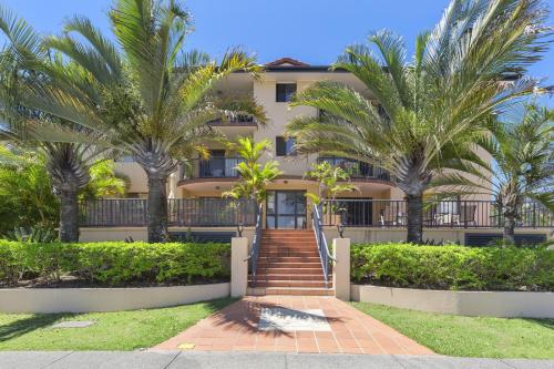 a building with palm trees in front of it at Aria Del Mare in Gold Coast