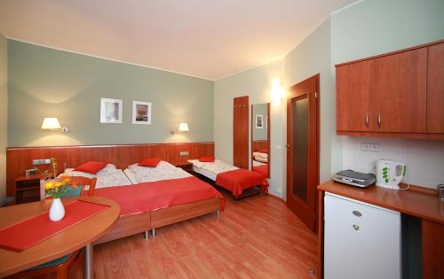 a hotel room with two beds and a kitchen at Penzion Fan in Karlovy Vary