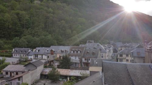 un groupe de maisons dans une ville où le soleil brille dans l'établissement T2 Bis Luchon, à Luchon