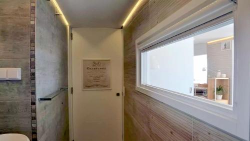 a bathroom with a window and a door with a window at Panorama Penthouse in Espinho