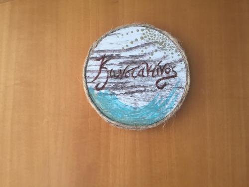 a rock with writing on it on a wooden wall at Phoenix Beachside Condos in Kokóni