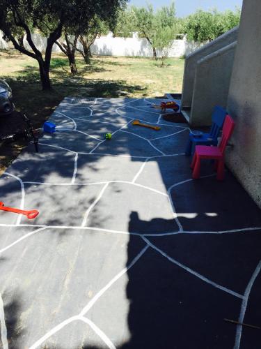a painted basketball court with a chair on a patio at Phoenix Beachside Condos in Kokóni