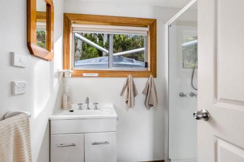 un bagno con lavandino e finestra di Summertime Cottage a Southport