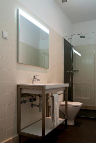 a bathroom with a sink and a toilet and a mirror at The Visionaire Apartments in Lisbon