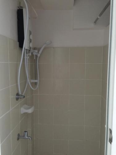 a shower with a shower head in a bathroom at Cityland Jane's Apartment in Tagaytay