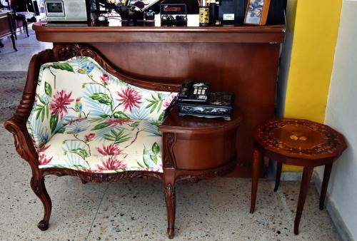 a wooden chair with a floral pillow next to a table at Hotel Mary Carmen in Cozumel