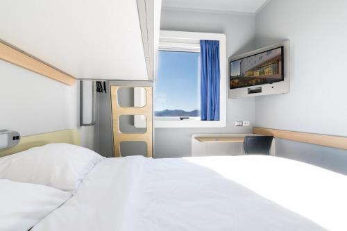 a bedroom with a white bed and a television at ibis budget Calama in Calama
