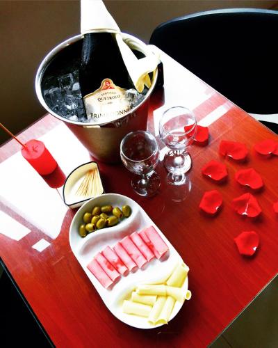 a table with a plate of cheese and a bottle of wine at Hotel Selva Dorada in Iquitos