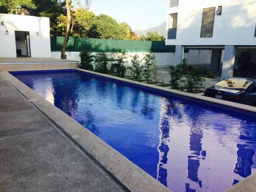 a swimming pool in front of a house at Cómodo y lindo depa con Alberca in Puerto Vallarta