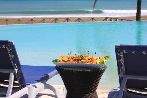 a bowl of food sitting on a chair next to a pool at Playa Venao Hotel Resort in Playa Venao
