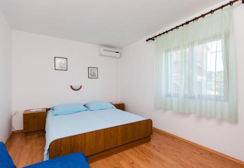 a bedroom with a bed and a window at Apartments Dragan in Lopar